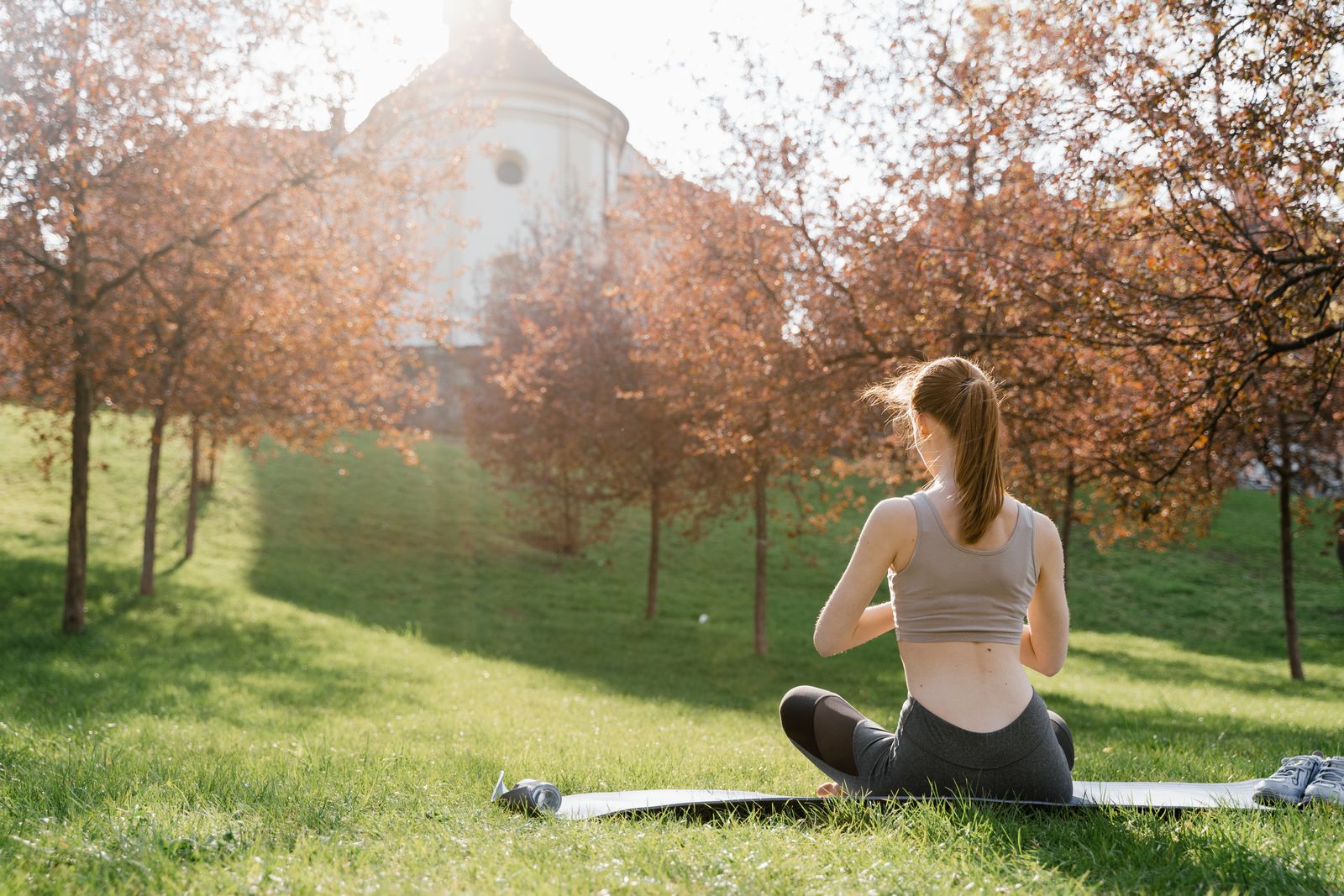 Woman meditating outdoors in a sunny park